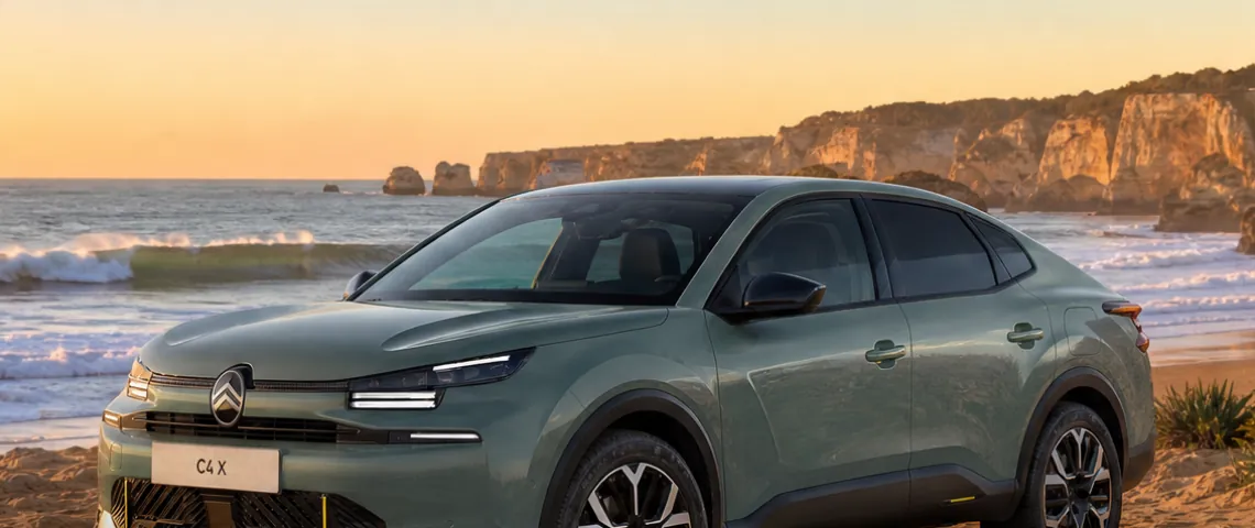 Citroën C4 X MAX w kolorze zielonym na plaży o zachodzie słońca